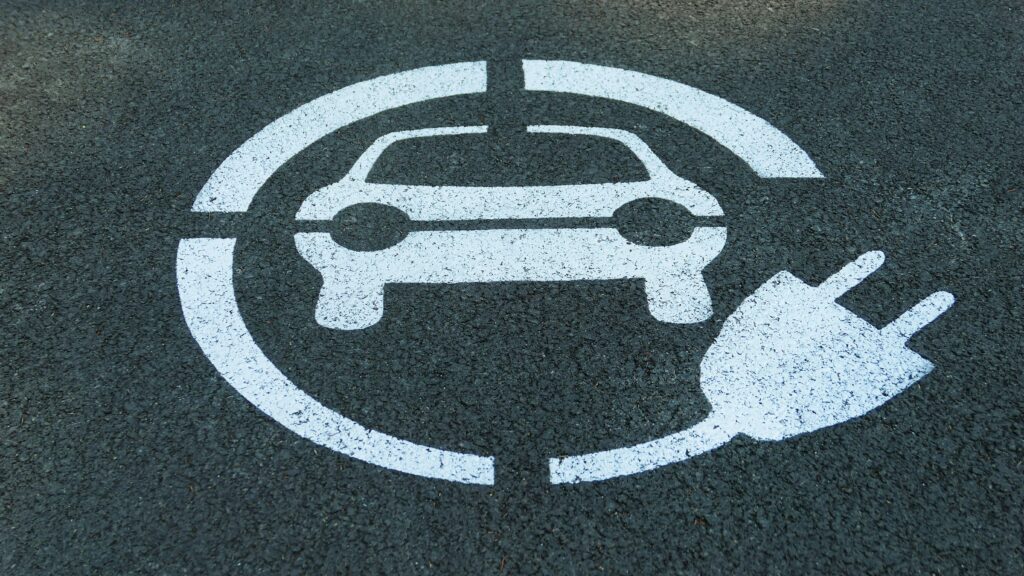 Close-up of an electric car parking sign painted on asphalt for charging stations.